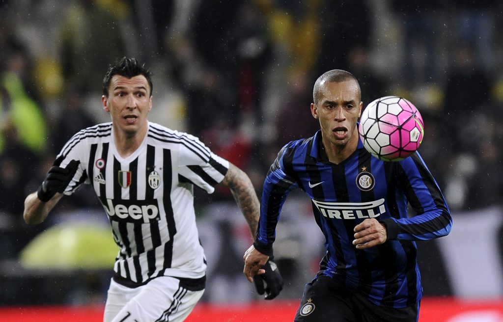 Juventus' Mario Mandzukic (L) in action against Inter Milan's Miranda (R).