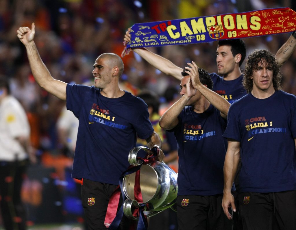 Victor Valdes (L-R) holds the Champions League trophy as he celebrates Barcelona's Champions League victory with teammates Xavi Hernandez, Sergi Busquets and Carles Puyol.