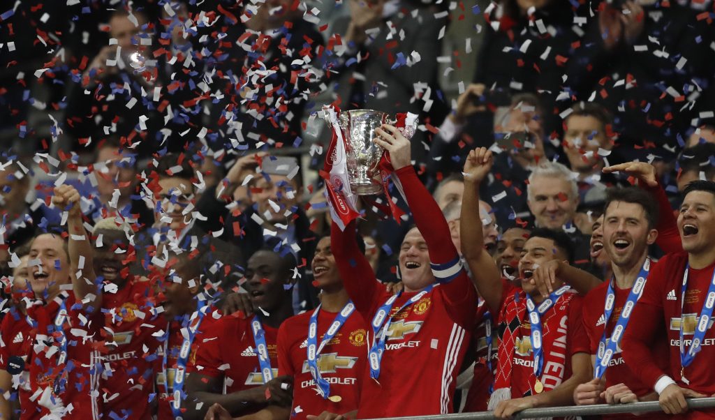 Manchester United's Wayne Rooney celebrates by lifting the trophy at the end of the match.