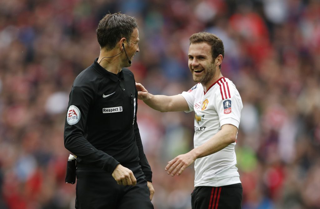 Manchester United's Juan Mata with referee Mark Clattenburg.