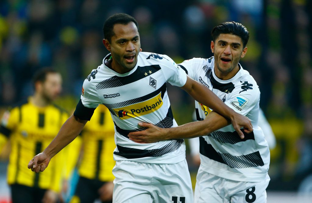 Borussia Moenchengladbach's Raffael celebrates with his teammate Mahmoud Dahoud after scoring a goal.