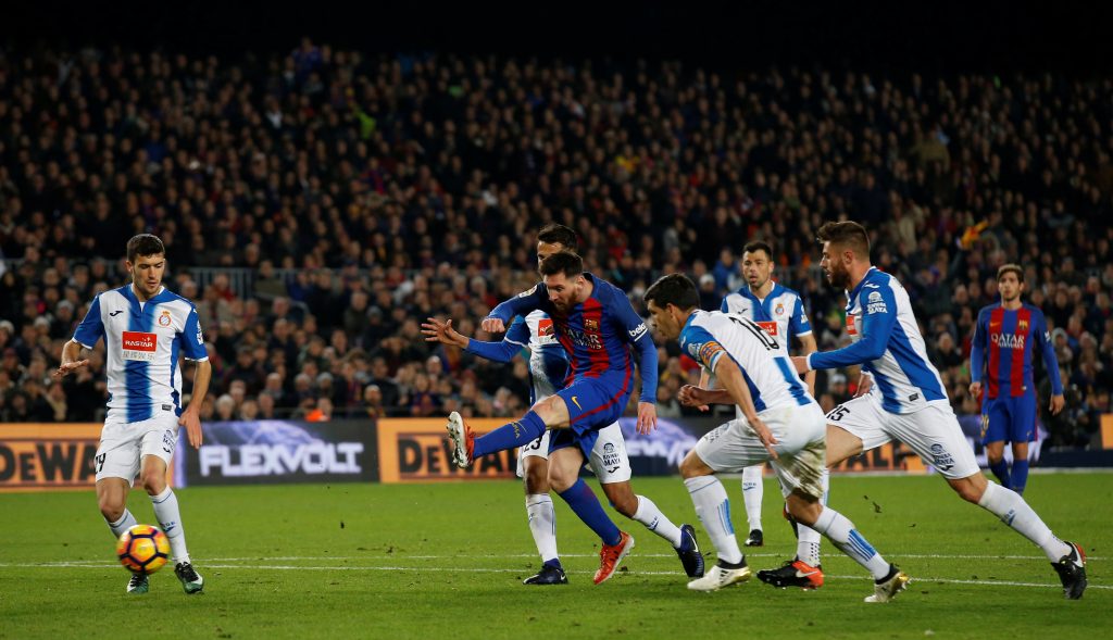 Barcelona's Lionel Messi shoots a ball against Espanyol's Javi Lopez, Diego Reyes and Gerard Moreno.