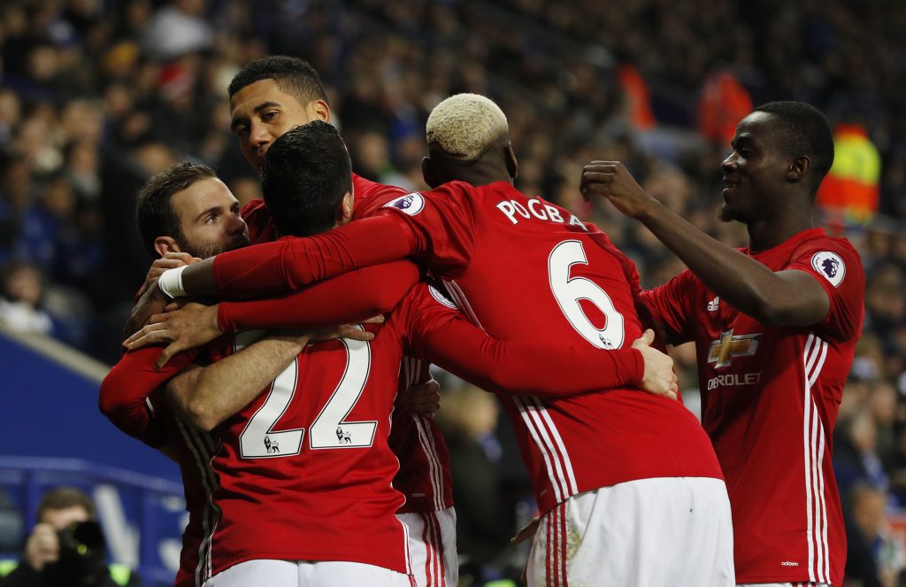 Manchester United's Juan Mata celebrates with teammates after scoring their third goal.