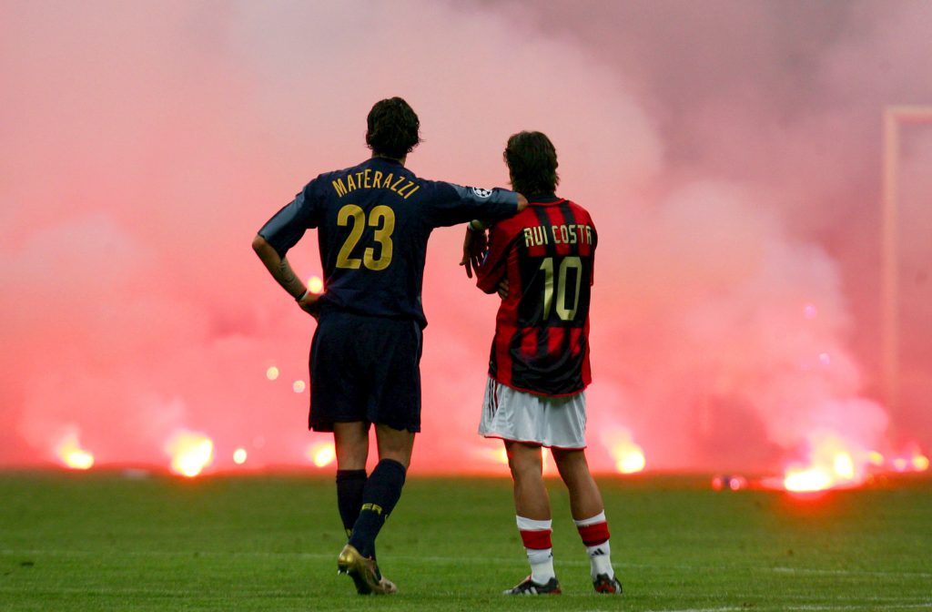 Inter Milan's Materazzi and Rui Costa of AC Milan wait on the pitch.