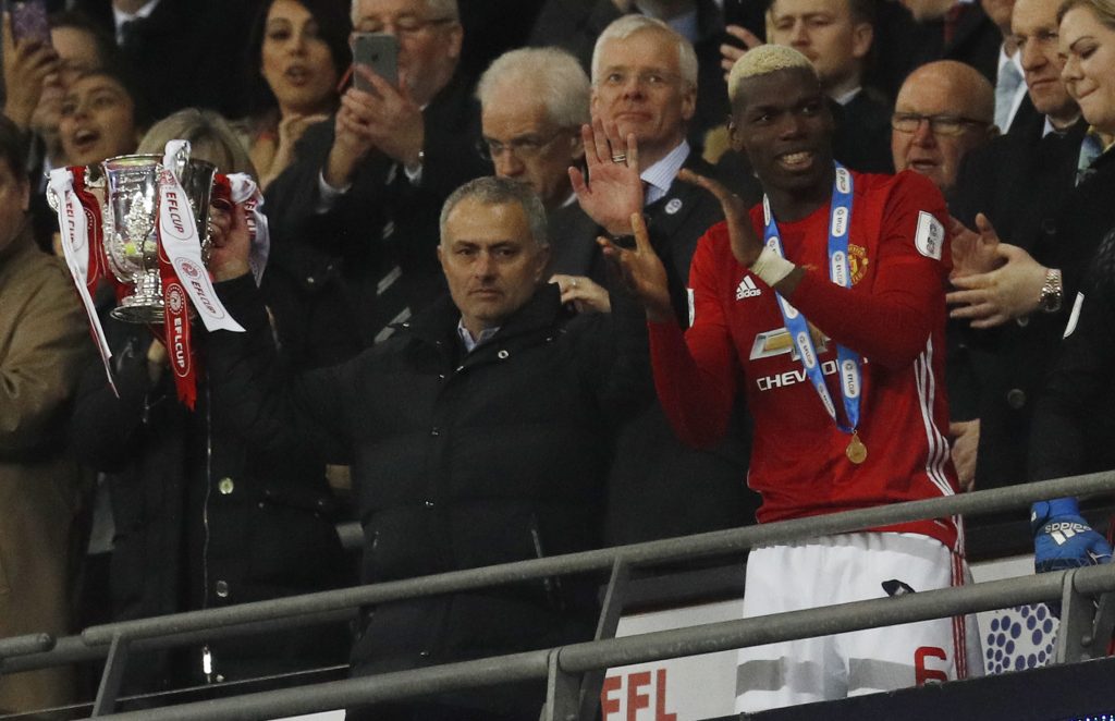 Manchester United manager Jose Mourinho lifts the trophy to celebrate winning.