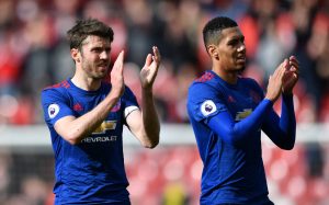 Manchester United's Michael Carrick and Chris Smalling applaud fans after the game.