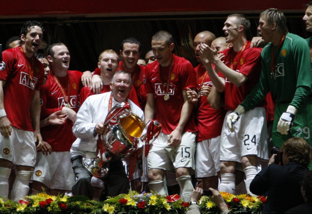 Manchester United manager sir Alex Ferguson (C) holds the trophy.