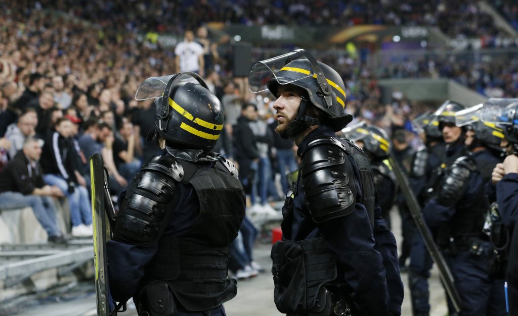 Police officers by the pitch after Lyon and Besiktas fans clashed in the stands.