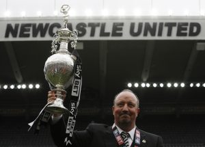 Newcastle manager Rafael Benitez celebrates winning the league with the trophy.