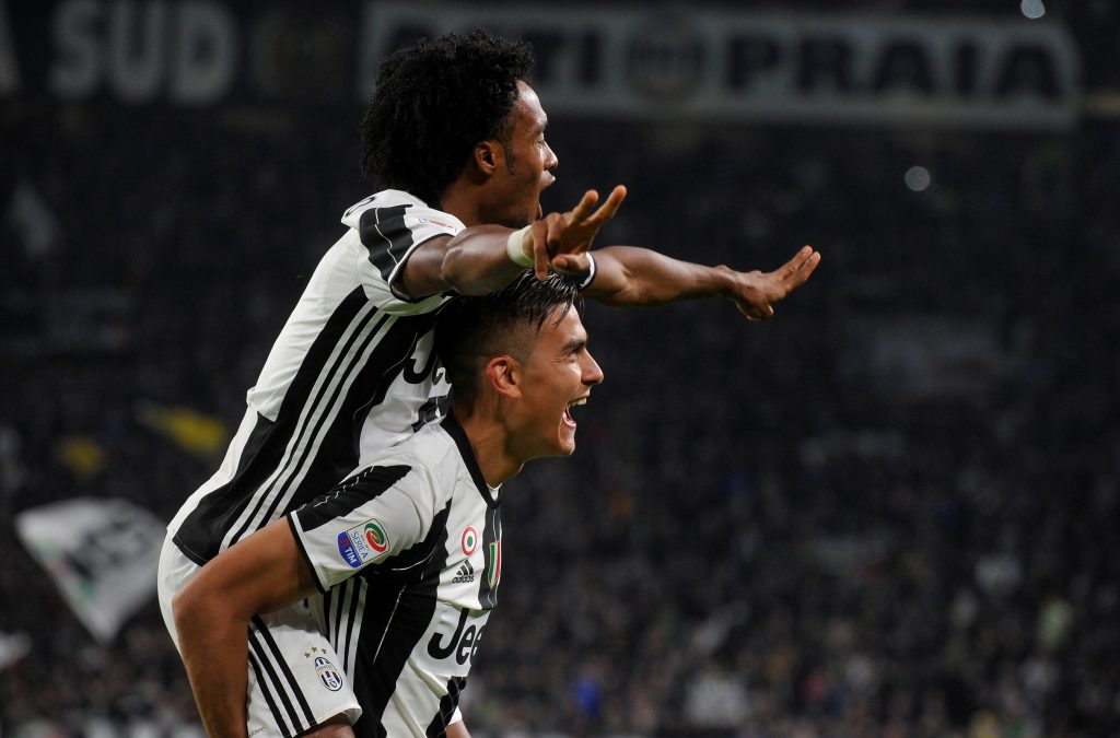 Juventus' Paulo Dybala (bottom) celebrates with his team mate Juan Cuadrado after scoring his second goal.