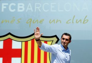 Coach Ernesto Valverde poses in front of FC Barcelona's giant logo.