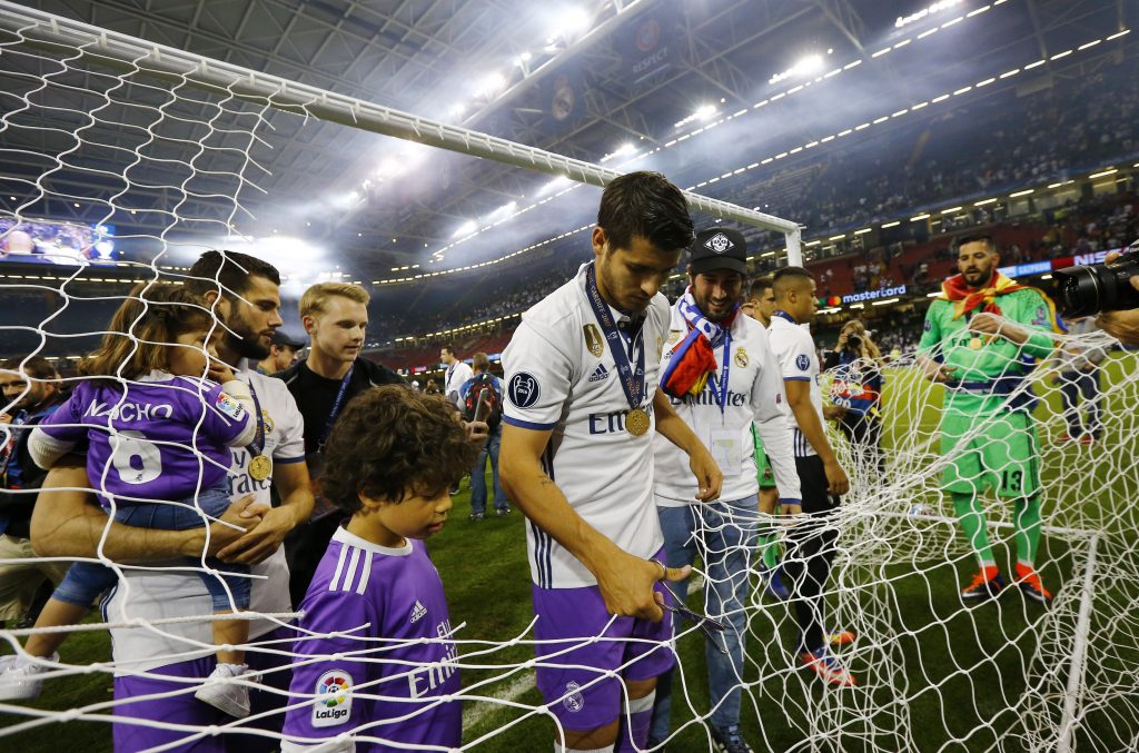 Real Madrid's Alvaro Morata cuts a part of the netting from the goal after winning the UEFA Champions League Final.