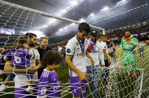 Real Madrid's Alvaro Morata cuts a part of the netting from the goal after winning the UEFA Champions League Final.