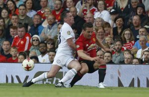 Michael Carrick All-Stars' Jamie Carragher in action with Manchester United '08 XI's Gary Neville.