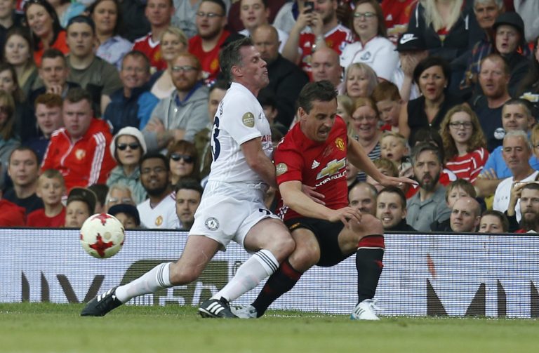 Michael Carrick All-Stars' Jamie Carragher in action with Manchester United '08 XI's Gary Neville.