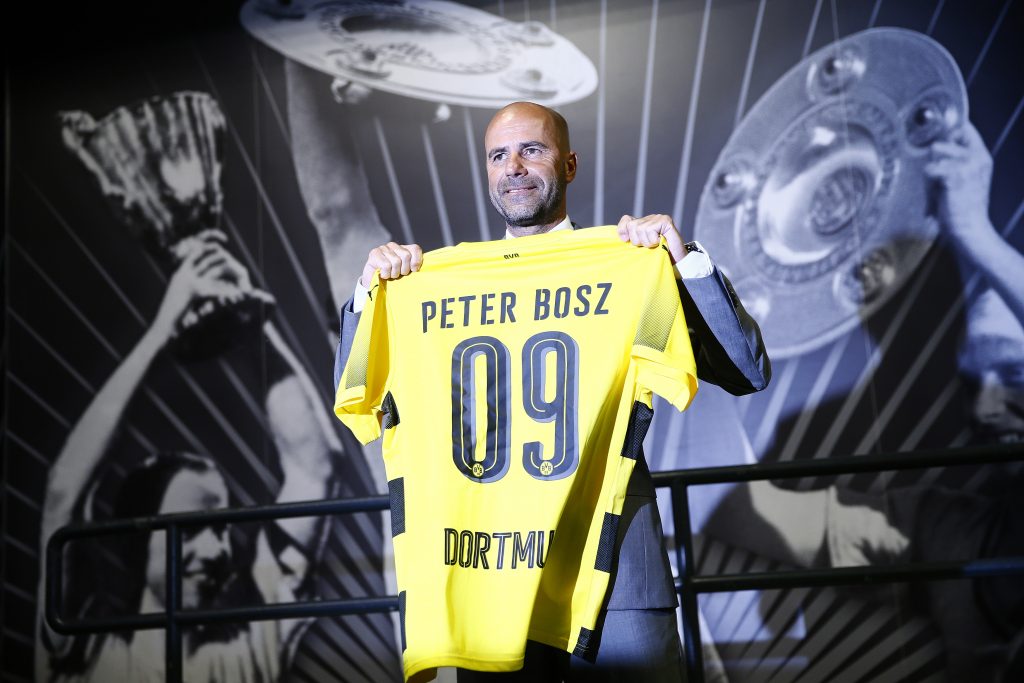 Dutch soccer coach Peter Bosz poses with a jersey as he is presented to the media as new coach of German soccer cup winner Borussia Dortmund.