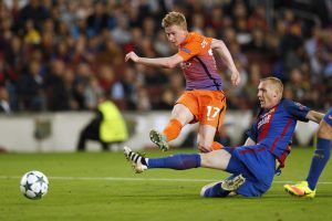 Manchester City's Kevin De Bruyne shoots at goal under pressure from Barcelona's Jeremy Mathieu.
