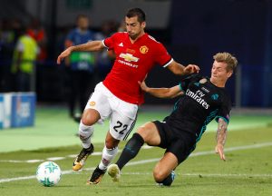 Henrikh Mkhitaryan in action with Toni Kroos.