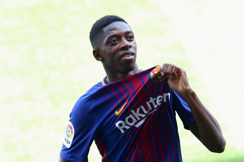F.C. Barcelona's new signing Ousmane Dembele shows off club's seal.