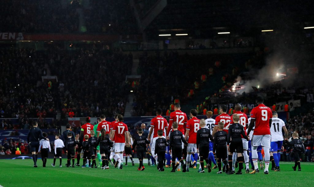 The teams walk out onto the pitch before the match.