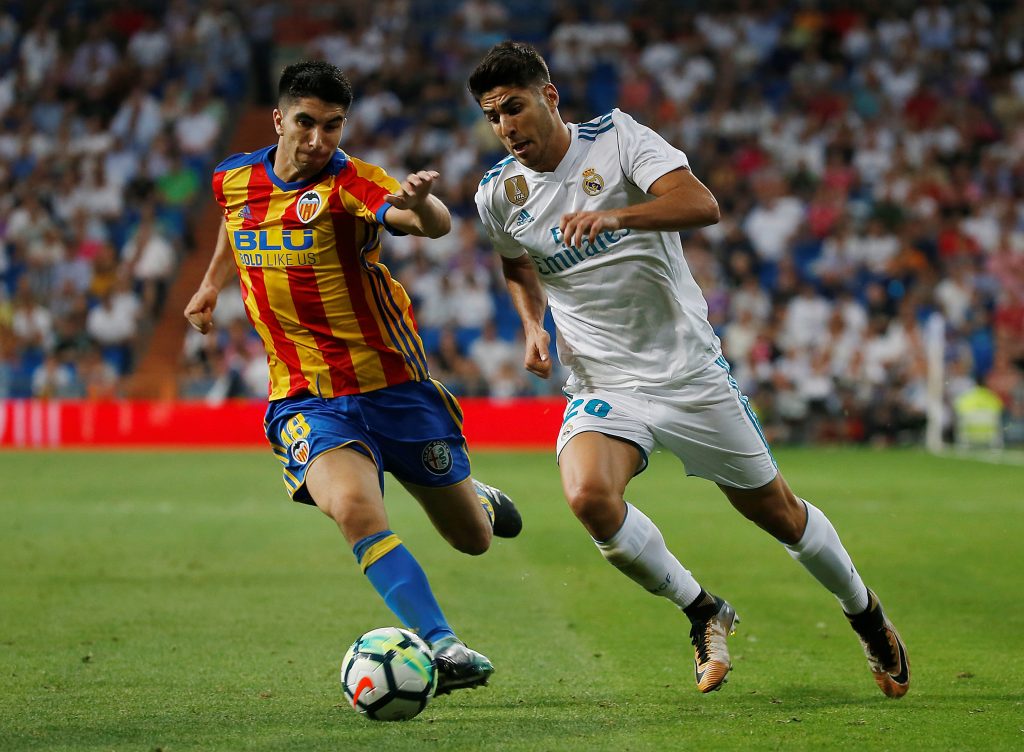 Real Madrids Marco Asensio in action with Valencia's Carlos Soler.