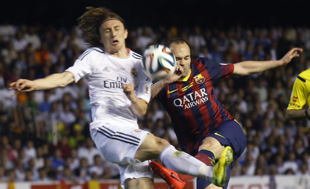 Barcelona's Andres Iniesta (R) and Real Madrid's Luka Modric challenge for the ball.