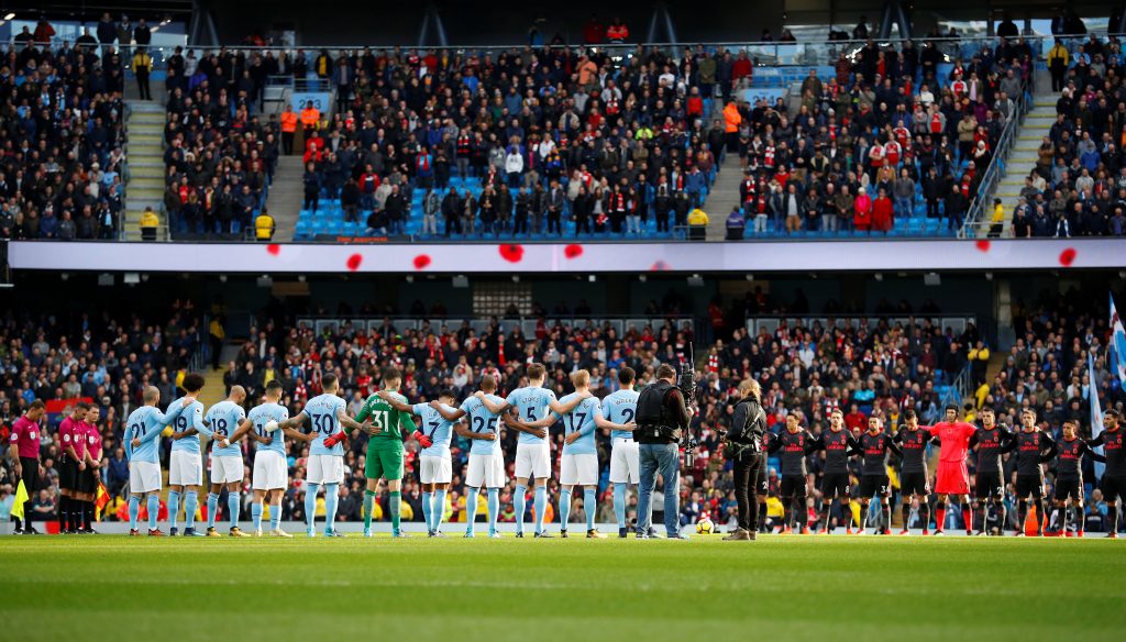 The players during a minutes silence as part of remembrance commemorations before the match.