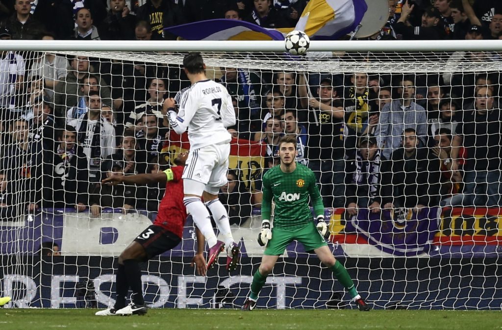 Cristiano Ronaldo scores past David De Gea (R).