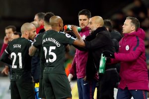 Man City manager Pep Guardiola talks to Fernandinho and David Silva during break in play.