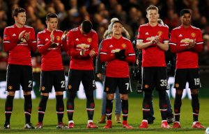 Manchester United players observe a minute's applause in memory of Jimmy Armfield before the match.