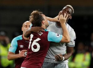West Ham United's Mark Noble clashes with Manchester United's Paul Pogba.