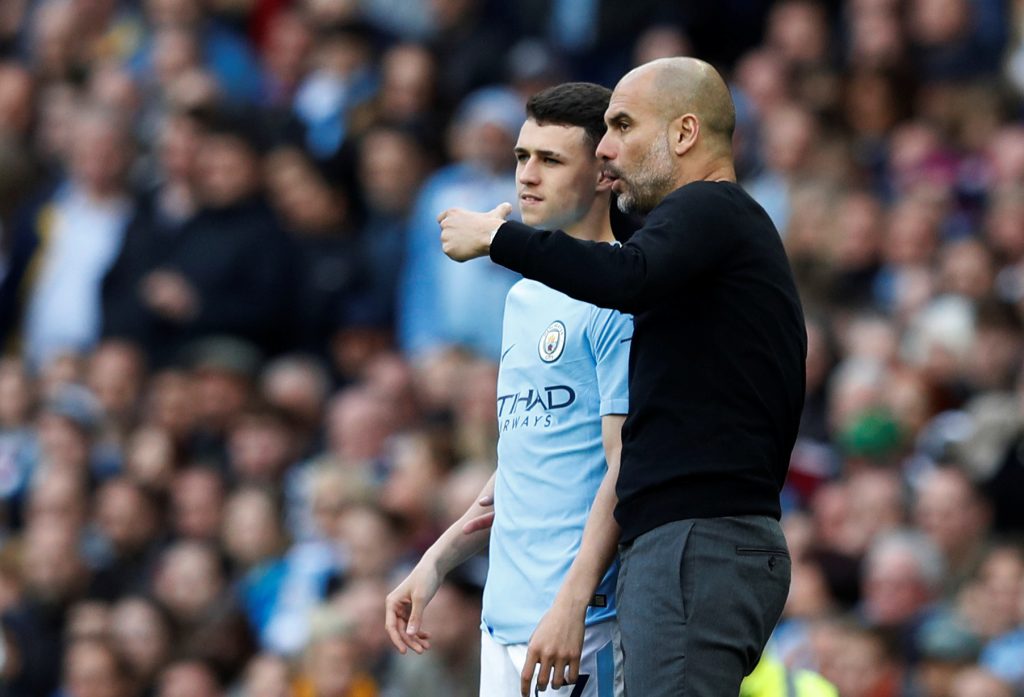 Manchester City's Phil Foden is spoken to by manager Pep Guardiola before he comes on as substitute.