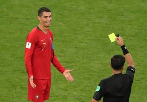 Portugal's Cristiano Ronaldo is shown a yellow card by referee Enrique Caceres.