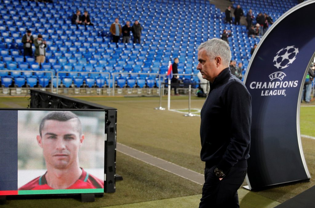 Jose Mourinho walks past a picture of Cristiano Ronaldo before the match.