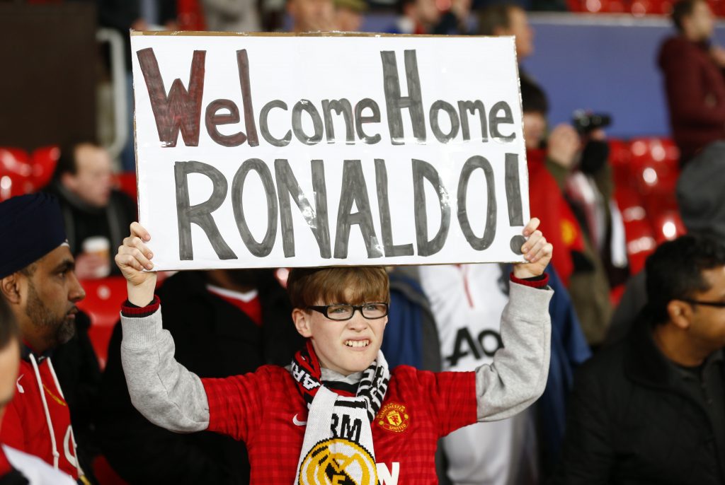 A Manchester United fan with a banner directed at Real Madrid's Cristiano Ronaldo.