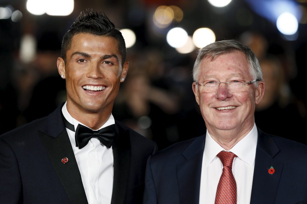 Soccer player Cristiano Ronaldo (L) and Sir Alex Ferguson pose for photographers on the red carpet.