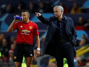 Jose Mourinho gestures while Alexis Sanchez looks on.