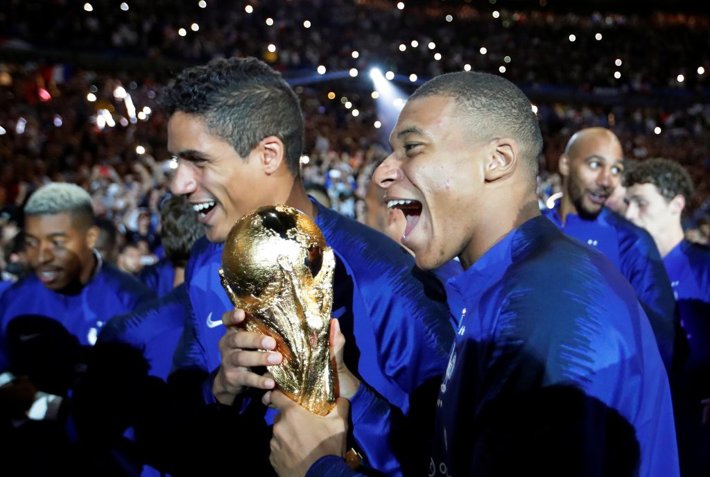 France's Kylian Mbappe and Raphael Varane celebrate with the World Cup trophy during a ceremony after the match.