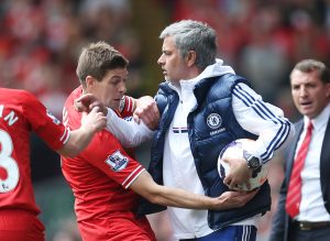 Liverpool's Steven Gerrard (L) attempts to get the ball off Chelsea manager Jose Mourinho.