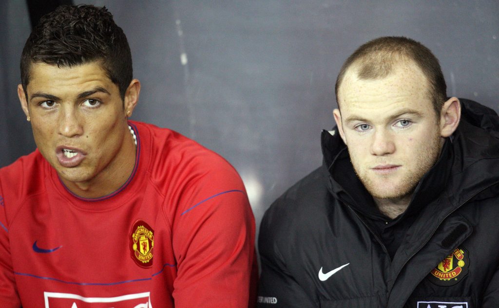 Manchester United's Cristiano Ronaldo and Wayne Rooney wait on the substitutes bench.