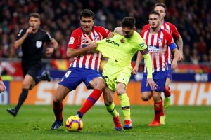 Atletico Madrid's Rodri in action with Barcelona's Lionel Messi.
