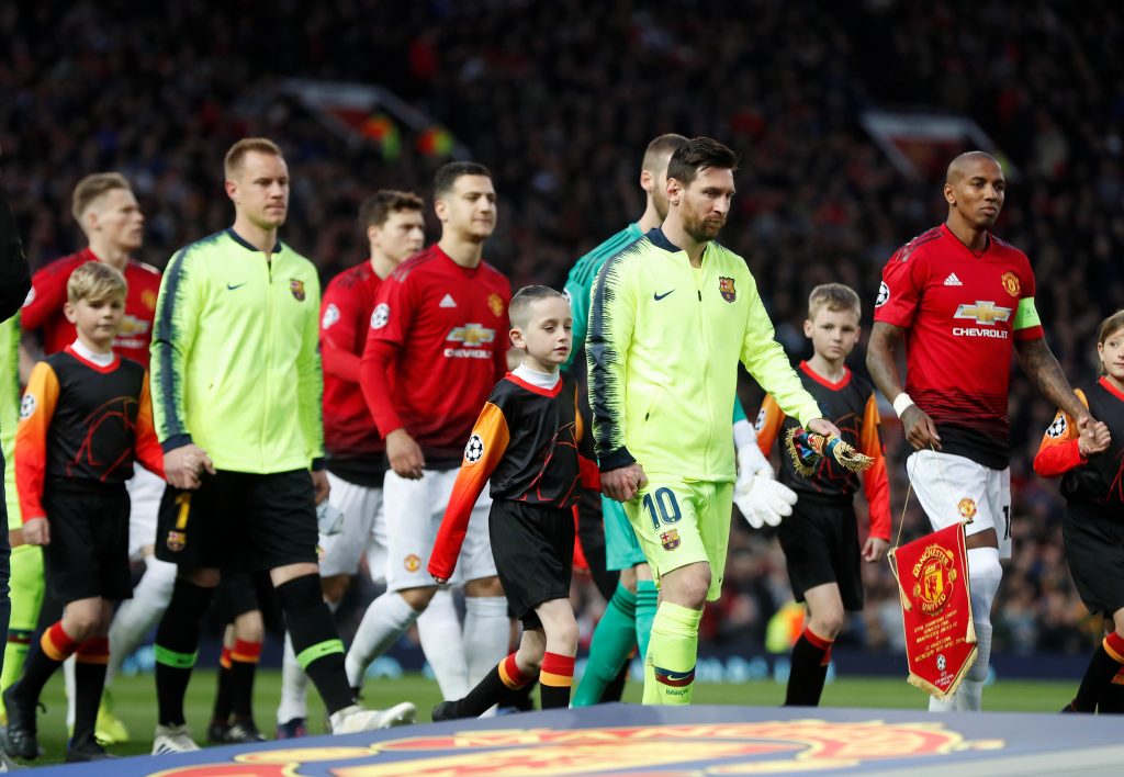 Barcelona's Lionel Messi and Manchester United's Ashley Young walk on to the pitch.