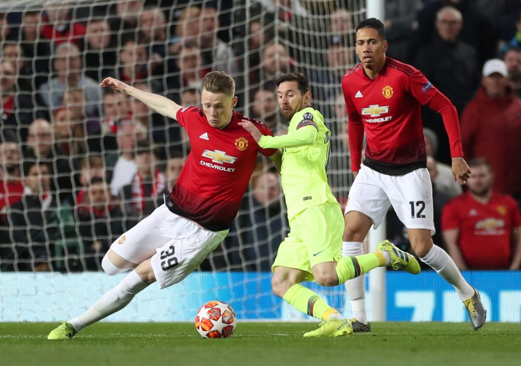 Manchester United's Scott McTominay and Chris Smalling in action with Barcelona's Lionel Messi.