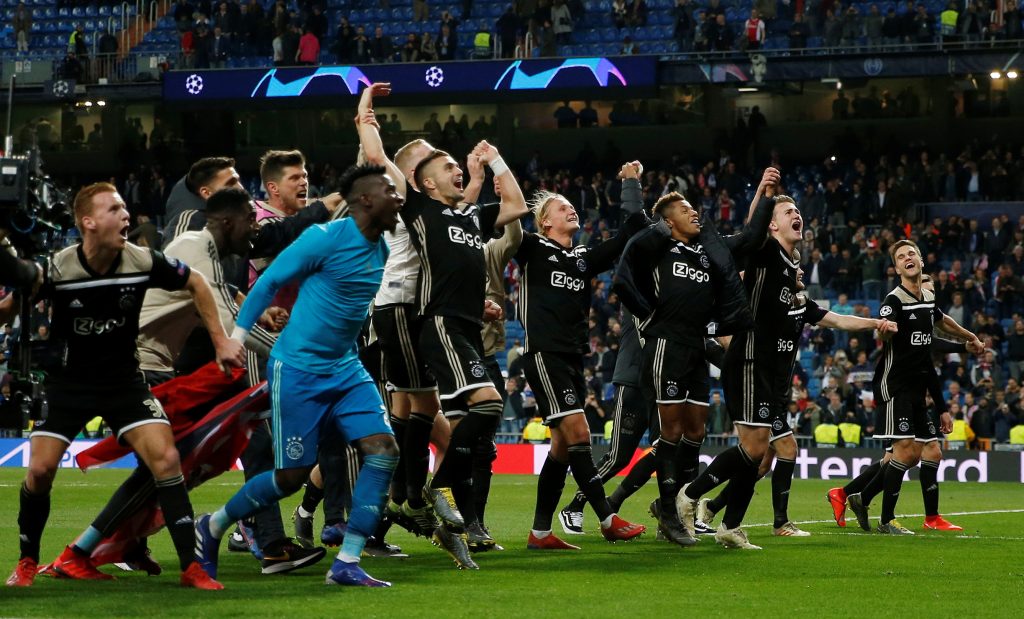 Ajax players celebrate in front of their fans at the end of the match.