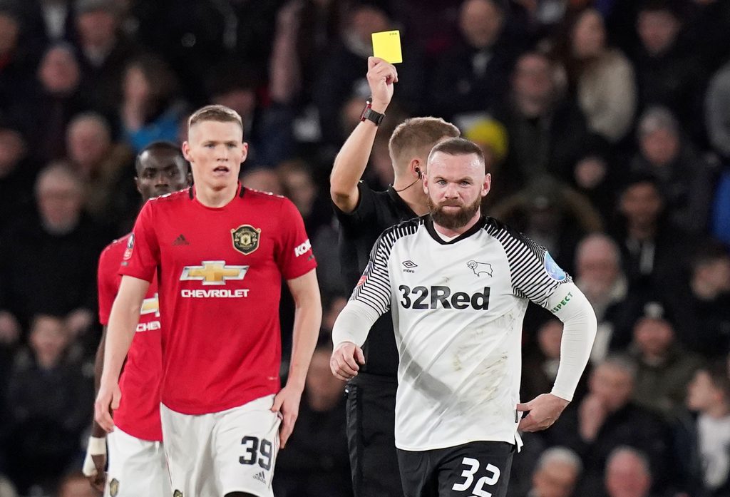 Wayne Rooney is shown a yellow card by referee.