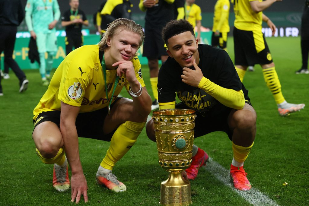 Erling Braut Haaland and Jadon Sancho celebrate winning the DFB Cup trophy.