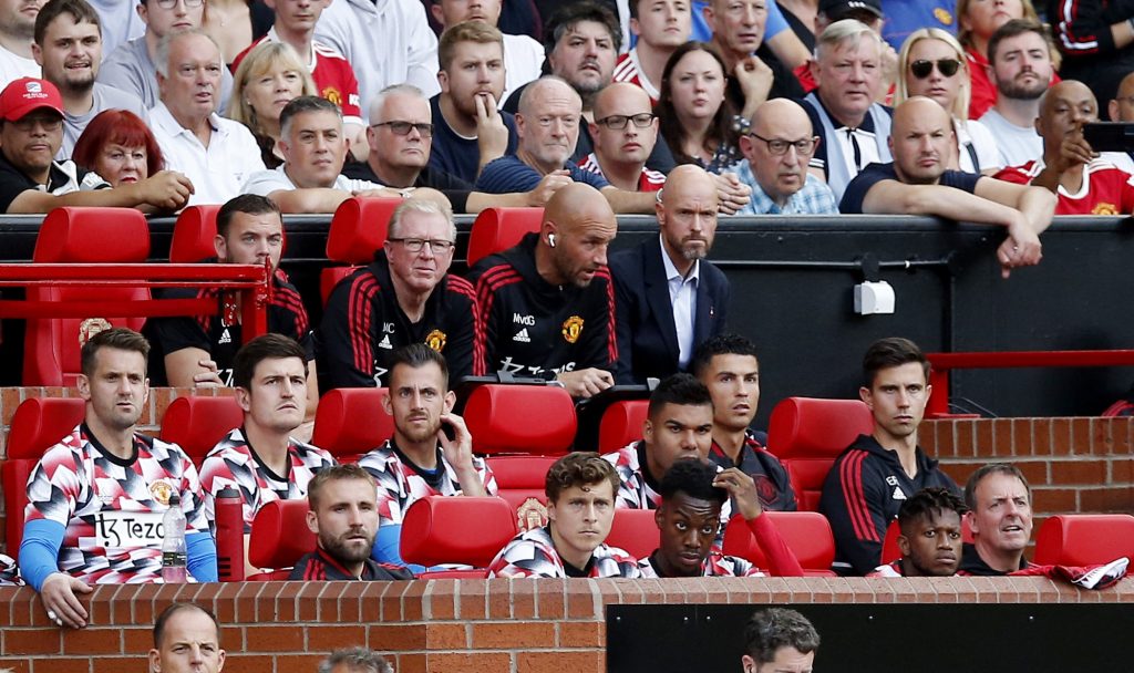 Manchester United manager Erik ten Hag with his coaching staff on the bench.
